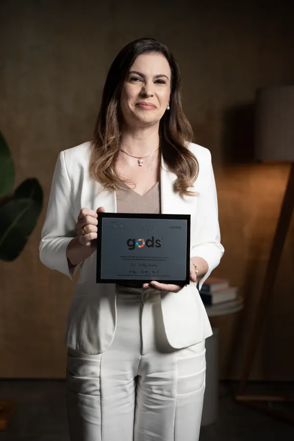 Kelly Fardin segurando a placa GODS&reg;